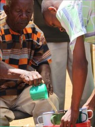 Rev Mwasapile (left) pouring our his "miracle cure"