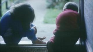 Young girl and boy sat in doorway