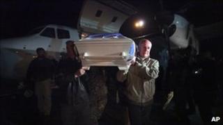 The head of the UN Assistance Mission in Afghanistan (Unama), Staffan de Mistura, carries the coffin of a UN staff member killed in the attack in Mazar-e Sharif from a jet a Kabul airport (2 April 2011)