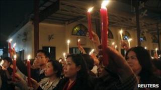 Lawyer Cu Huy Ha Vu's wife Nguyen Thi Duong Ha (C) holds a candle at a vigil for his release in Hanoi on 2 April 2011