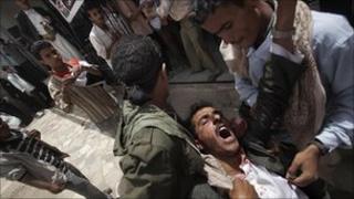 Injured Yemeni protester is carried in Sanaa (5 April 2011)