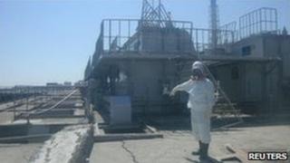 A worker points to a crack in a concrete pit near Fukushima Daiichi's No 2 reactor, 2 April