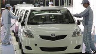 Workers give the final check to Toyota cars