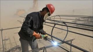 A labourer welds steel bars