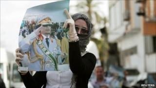 A supporter displays a picture of Libyan leader Muammar Gaddafi during an anti-coalition protest in Tripoli, 2 April 2011