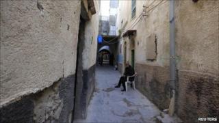 A Libyan man sits by his house along one of the narrow streets in the old city of Tripoli, 6 April 2011.
