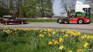 An Eddie Stobart truck leads the hearse away after Edward Stobart's funeral