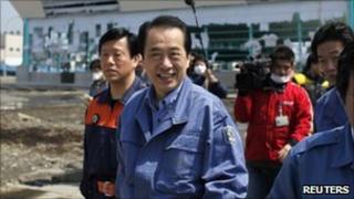 Naoto Kan walks through ruins during a visit to a fishing port in Ishinomaki, Miyagi prefecture April 10, 2011