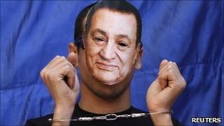 A protester wears a mask depicting ousted Egyptian president Hosni Mubarak during a protest in Tahrir square, April 8, 2011