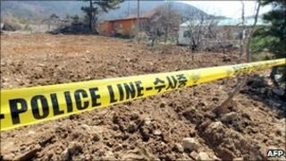 An excavated garlic field is seen behind a police line after police found buried cash, in the southwestern city of Gimje