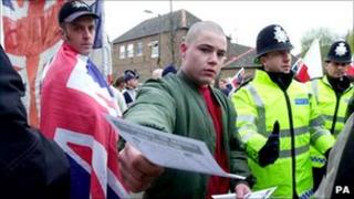 A marcher hands out a leaflet at a National Front march in London