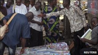 Men gather at a newspaper vendor's stall in Lagos, Nigeria