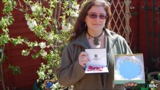 Jo Wood in her garden with her MBE and her Cheshire Woman of the Year plaque