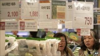 Customers buy vegetables at a store in Seoul