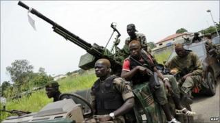 Pro-Ouattara armed militiamen patrol in a district of Abidjan on 13 April 2011.