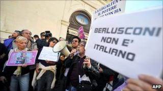 People protest outside Italy's lower house of parliament in Rome, 13 April 2011