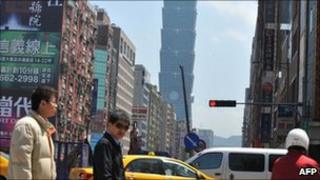 Pedestrians walk in Taipei on April 6, 2011
