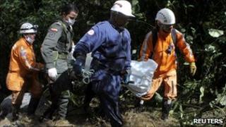 Rescue workers carry a victim of the bus accident on the Manizales-Bogota road in Colombia