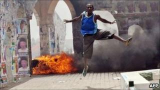 A man jumps during a demonstration in Nigeria's northern city of Kano where running battles broke out between protesters and soldiers on 18 April 2011