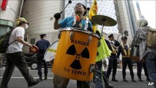 A protester in front of a Tepco showroom