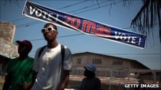 Haitians passing election banner, March 2011