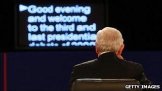 A man sitting in front of a teleprompter