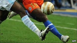 Two black footballers chase the ball at the Marseille-Montpellier French League Cup final in Paris, 23 April