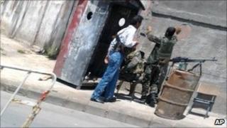 Photo taken from mobile phone through a car window of two Syrian soldiers and armed man in civilian clothes at checkpoint in Damascus, Syria - 1 May 2011