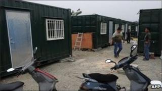 Workers modify freight containers that are being converted into houses in Puli, central Nantou county on 28 April 2011