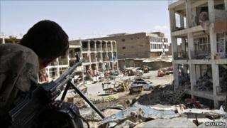 An Afghan border police keeps watch from a building which was used by the Taliban forces to attack the Kandahar governor"s office in Kandahar city May 8, 2011