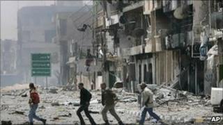 Residents run through damaged streets in Misrata, Libya (23 April 2011)