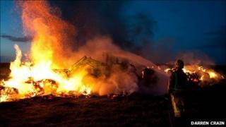 A tractor is used to help tackle the fire