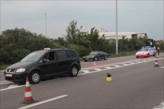 A police car stands behind the taxi involved in the shooting at Brussels airport, 11 May