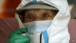 A villager wears a protective suit ahead of a visit to her house located near the Fukushima Daiichi nuclear power plant