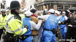 Police and Chinese security officers tackle a protester during the London leg of the Beijing torch relay