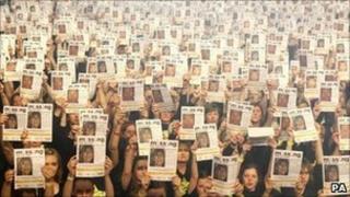 10 000 участников Рока Хора держат плакаты с фотографиями пропавших детей на Уэмбли-Арене