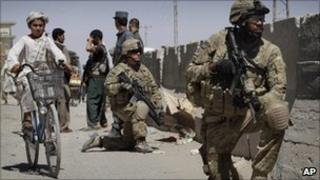 US. soldiers take position near the scene of an explosion in Kandahar south of Kabul, Afghanistan on Sunday, May 22, 2011