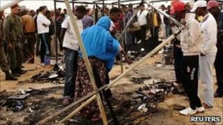 Refugees gather around a burnt tent on 23 May 2011 at a refugee camp in Choucha, Tunisia