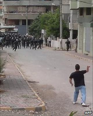 Police run towards a man in Baniyas, Syria, 27 May 2011