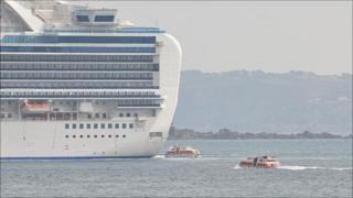 Cruise ship liberty boats travel to and from the Crown Princess anchored off Guernsey