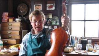Christoph Gotting holding a violin he made