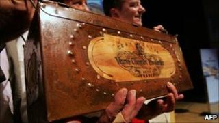 Auctioneers hold up a specially-made box for a bottle of Veuve Clicquot in Mariehamn