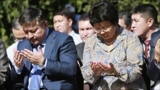 Kyrgyz President Roza Otunbayeva (R) and Parliament Speaker Ahmatbek Keldibekov (L) pray during a ceremony of remembrance in the city of Osh June 10, 2011