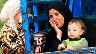 Syrian women who fled the unrest in Syria wait at a makeshift camp in the northern city of Idlib, near the Turkish village of Guvecci in Hatay, on 13 June 2011