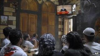 Syrian citizens watch President Assad's speech in a Damascus cafe, 20 June