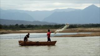 Fishermen throw a net out over the Pilcomayo River