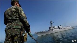A Philippine naval personnel stands on guard during the arrival of missile destroyer USS Chung Hoon in Palawan