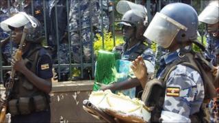 Police in Kampala, Uganda, walk away with a birthday cake for President Museveni