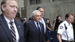 Dominique Strauss-Kahn, centre, leaves a New York court on 6 June 2011
