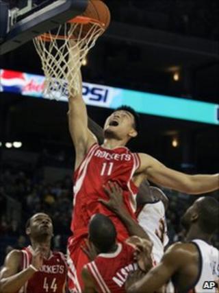 Yao Ming dunking a basketball and scoring against the Golden State Warriors in 2006